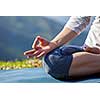 Close up of woman in Padmasana yoga lotus pose with chin mudra outdoors with copyspace