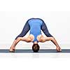 Beautiful sporty fit woman practices Ashtanga Vinyasa yoga asana Prasarita padottanasana D - wide legged forward bend D