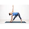 Beautiful sporty fit woman practices Ashtanga Vinyasa yoga asana utthita trikonasana - extended triangle pose