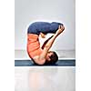 Sporty fit yogini woman practices inverted yoga asana Urdhva padmasana - lifted lotus pose