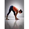 Sporty fit woman stretching in Ashtanga Vinyasa yoga asana Parsvottanasana - intense side stretch pose