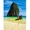 Long tail boat on tropical beach with limestone rock, Krabi, Thailand