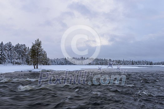 Northern river scenery in february with snow and ice