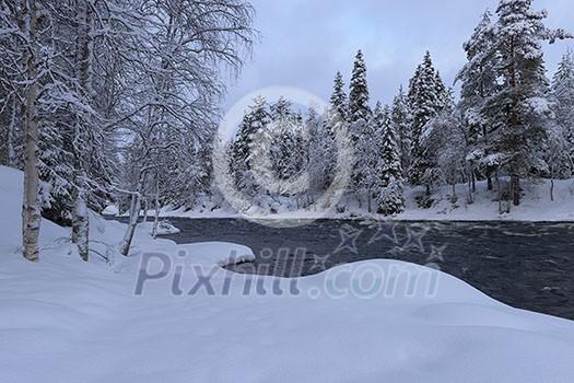 Northern river scenery in february with snow and ice