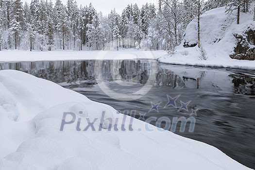 Northern river scenery in february with snow and ice