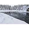 Northern river scenery in february with snow and ice