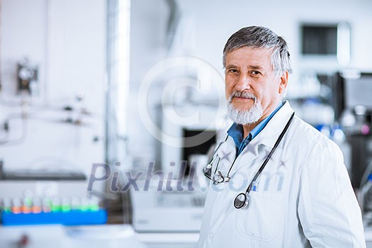 Senior doctor using his tablet computer at work (color toned image)