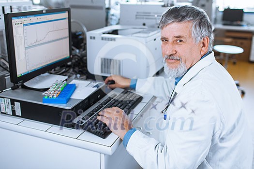 Senior researche rusing a computer in the lab while working on an experiment (color toned image) Senior researche rusing a computer in the lab while working on an experiment (color toned image)