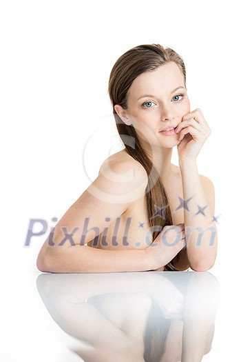 Beautiful, young woman isolated on white background with a reflection underneath her