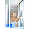 Pretty, young woman doing house work - washing windows