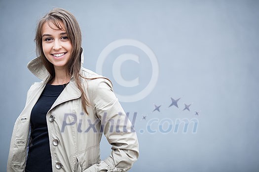 portrait of a pretty, young woman wearing an elegant coat in front of a grey wall (shallow DOF; color toned image)