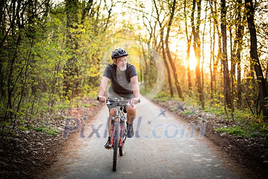 Senior man on his mountain bike outdoors (shallow DOF; color toned image) Senior man on his mountain bike outdoors (shallow DOF; color toned image)