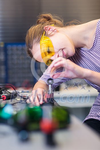 Female scientist carrying out research experiments in a quantum optics lab (color toned image)