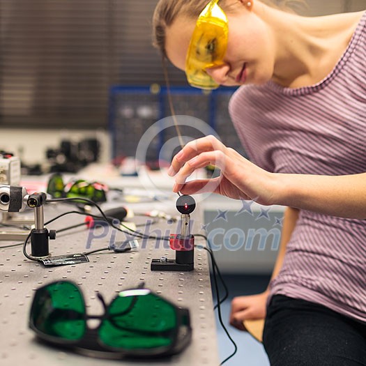 Female scientist carrying out research experiments in a quantum optics lab (color toned image)