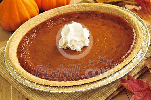 Whole pumpkin pie with fresh whipped cream