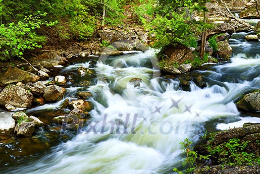 Water rushing among rocks in river rapids in Ontario Canada