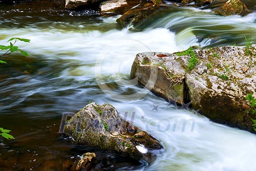 Water rushing among rocks in river rapids in Ontario Canada