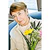 Portrait of sad elderly woman holding flowers