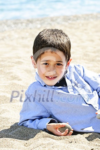 Portrait of young boy laying on sand at the beach Portrait of young boy laying on sand at the beach