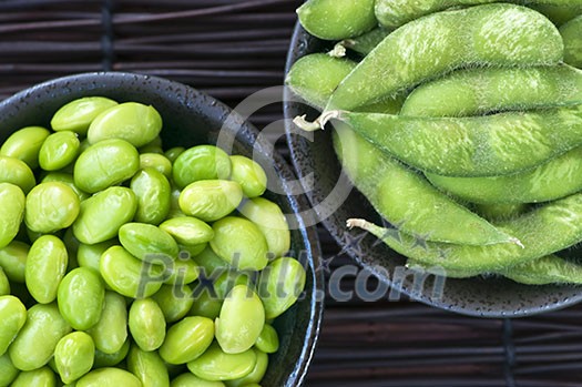 Edamame soy beans shelled and with pods in bowls