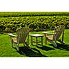 Muskoka chairs and table near vineyard at winery