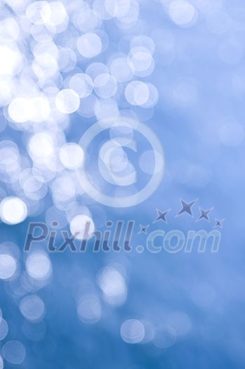 Out of focus bokeh background of blue water with sun reflections. Can be used as Christmas or winter backdrop. Out of focus bokeh background of blue water with sun reflections. Can be used as Christmas or winter backdrop.