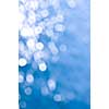 Out of focus bokeh background of blue water with sun reflections. Can be used as Christmas or winter backdrop.