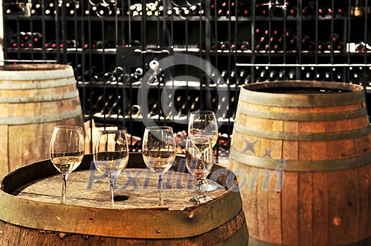 Row of wine glasses on barrel in winery cellar