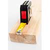 Metal imperial metric tape measure measuring two by four lumber