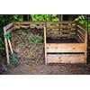 Large cedar wood compost boxes with composted soil and yard waste for backyard composting
