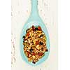 Homemade granola with various seeds and berries in wooden spoon shot from above
