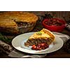 Slice of traditional pork meat pie Tourtiere with apple and cranberry chutney from Quebec, Canada.