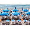 Blue umbrellas and chairs on pebble beach in Nice, France.