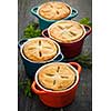 Four homemade gourmet meat pies on wooden background