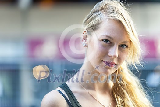 Portrait of serious young blonde woman looking at camera with copy space