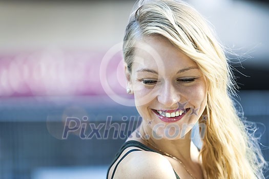 Candid portrait of young blonde woman laughing with copy space