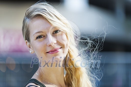 Portrait of young blonde smiling woman looking at camera