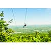 Young woman zip-lining with aerial countryside view at Blue Mountains, Ontario, Canada.