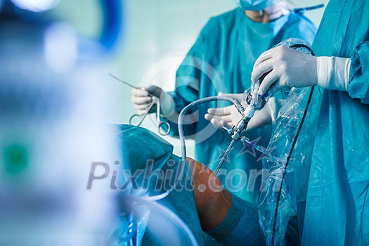 Knee surgery, Orthopedic Operation - two surgeons performing a knee surgery on a patient (shallow DOF; color toned image) Knee surgery, Orthopedic Operation - two surgeons performing a knee surgery on a patient (shallow DOF; color toned image)