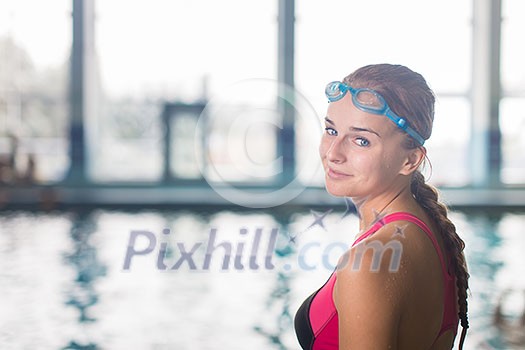Female swimmer in an indoor swimming pool - looking at the camera, smiling wholeheartedly (shallow DOF; color toned image) Female swimmer in an indoor swimming pool - looking at the camera, smiling wholeheartedly (shallow DOF; color toned image)