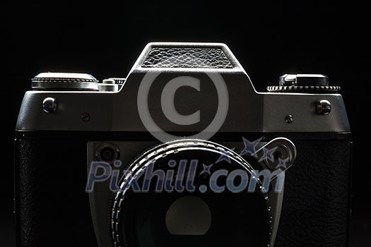 Old film camera - low key image - Modern DSLR camera with a very wide aperture lens on Old film camera - low key image - Modern DSLR camera with a very wide aperture lens on