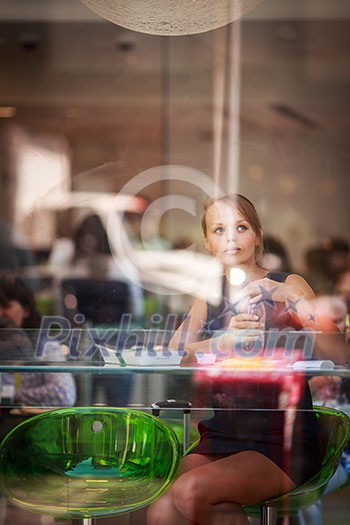 Pretty, young woman eating sushi in a restaurant, having her lunch break, enjoying the food, pausing for a while from her busy corporate/office life (color toned image)