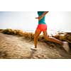 Young woman on her evening jog along the seacoast (motion blurred image)