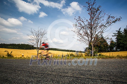 Motion blurred biker on a road