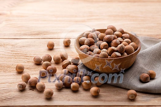 Hazelnuts in bowl on wooden table Hazelnuts in bowl on wooden table