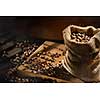 spilled coffee beans in bag on wooden table. Morning light