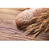 wheat and bread on wooden table, shallow DOF, raw image