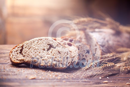 Bread and wheat on wooden table, shallow DOF, raw image Bread and wheat on wooden table, shallow DOF, raw image