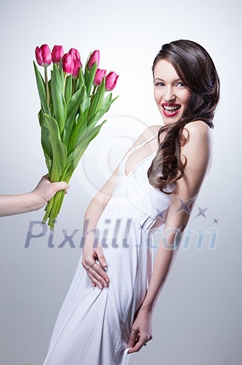 Smiling woman and hand with bouquet of pink tulips on white