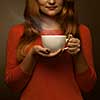 woman holding hot cup and smiles